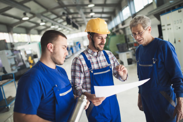 Manufacturing foreman discussing plans with employees and showing flexibility in production