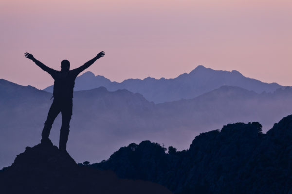 inspiring mountain landscape with climber standing on top of mountain