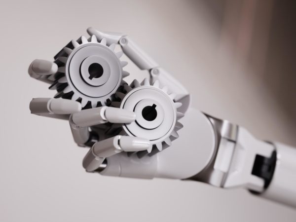 robot hand holding gears representing manufacturing automation